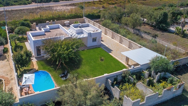 A modern house with a swimming pool, a covered patio, and a view of the sea. - 2092 Villa Il Fenicottero Salentino (Manduria)