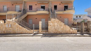 A multi-story building with balconies, a stone facade, and a clear sky. - 1930 Residence La Primula (Manduria)
