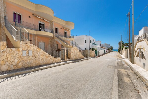 A street with multi-story buildings, stone walls, and balconies. - 1930 Residence La Primula (Manduria)