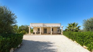 A modern building with a covered porch and a gravel driveway. - 2097 Villa Regina Dello Ionio (Manduria)