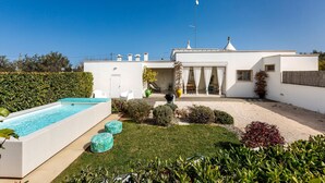 A modern house with a swimming pool, a covered patio, and a well-maintained garden. - 2124 I Colmi Trulli Suites (Martina Franca)