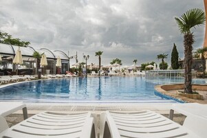 Una piscina al aire libre de temporada, sombrillas