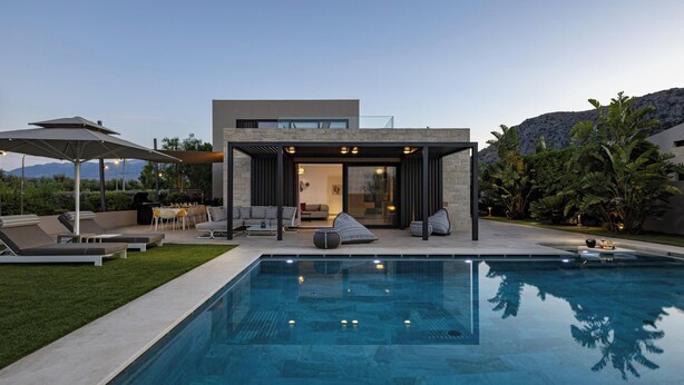 Ein modernes Haus mit Pool, Sitzgelegenheit im Freien und Blick auf Berge.