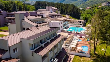 A hotel with multiple floors, a swimming pool, and a children's play area.