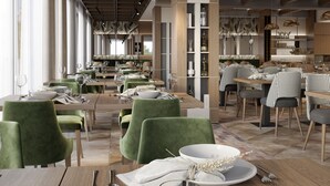 Ein geräumiges Restaurant mit hohen Decken, moderner Beleuchtung und einer Mischung aus grünen und neutralen Sitzgelegenheiten.