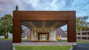 Ein modernes Gebäude mit Holzfassade und überdachter Eingangszone.