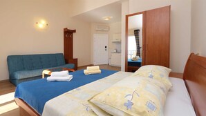 Une chambre d’hôtel avec un lit, un canapé, un bureau et un miroir.