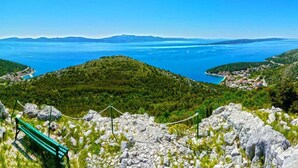 Un paysage montagneux offrant une vue dégagée sur une ville côtière et une étendue d’eau.