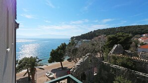 Vista sulla costa con spiaggia, una barca e un edificio in pietra.