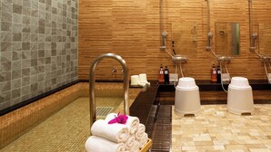 Un baño moderno con una pared de madera, suelo de baldosas y un lavabo con espejo.