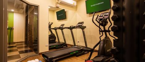 Un gimnasio en casa con cintas de correr, elípticas y mancuernas.