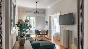 Ein modernes Wohnzimmer mit einer Couch, einem Couchtisch und einem an der Wand montierten Fernseher.