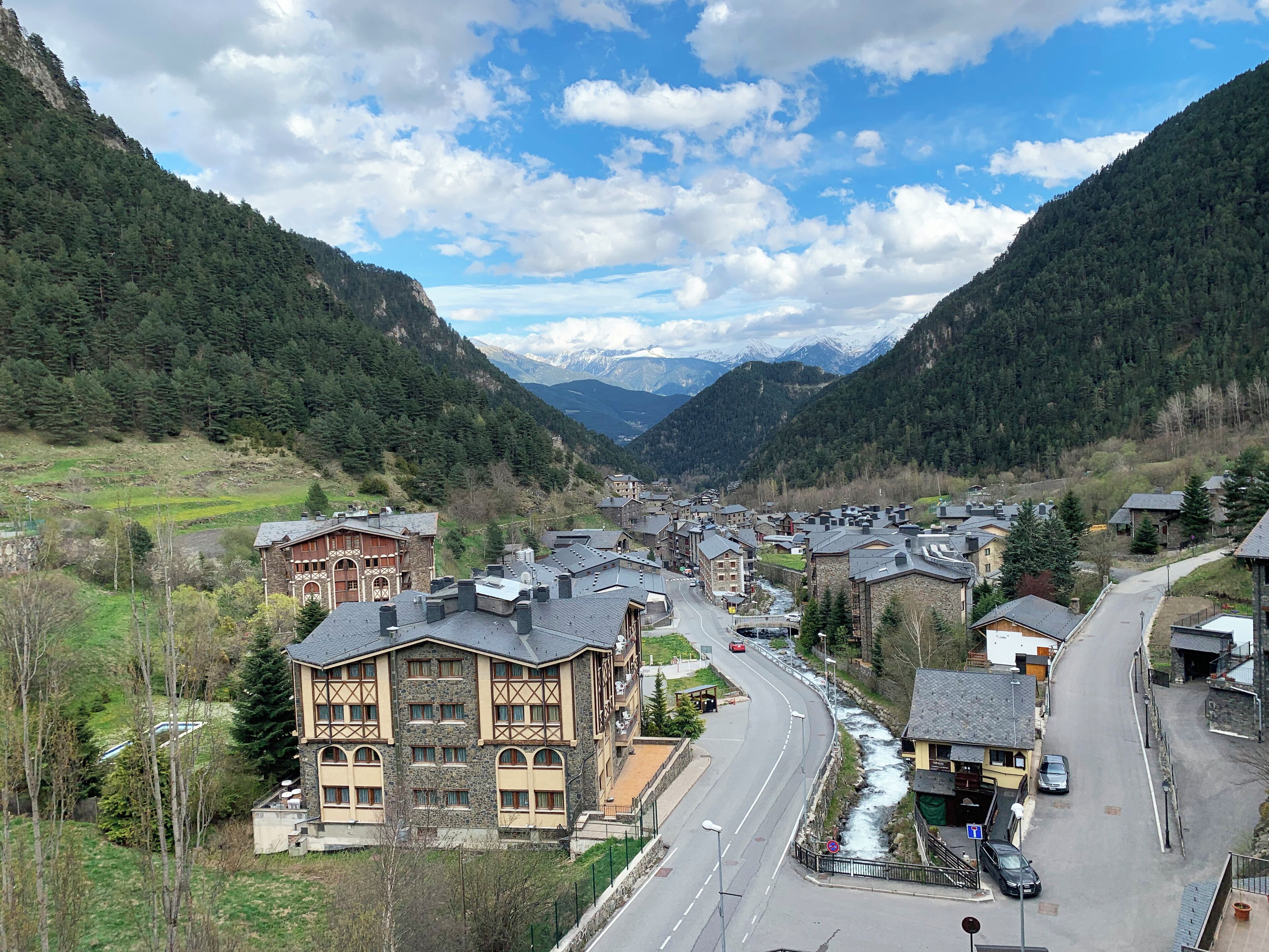 A mountain village with traditional architecture, a winding road, and a river.