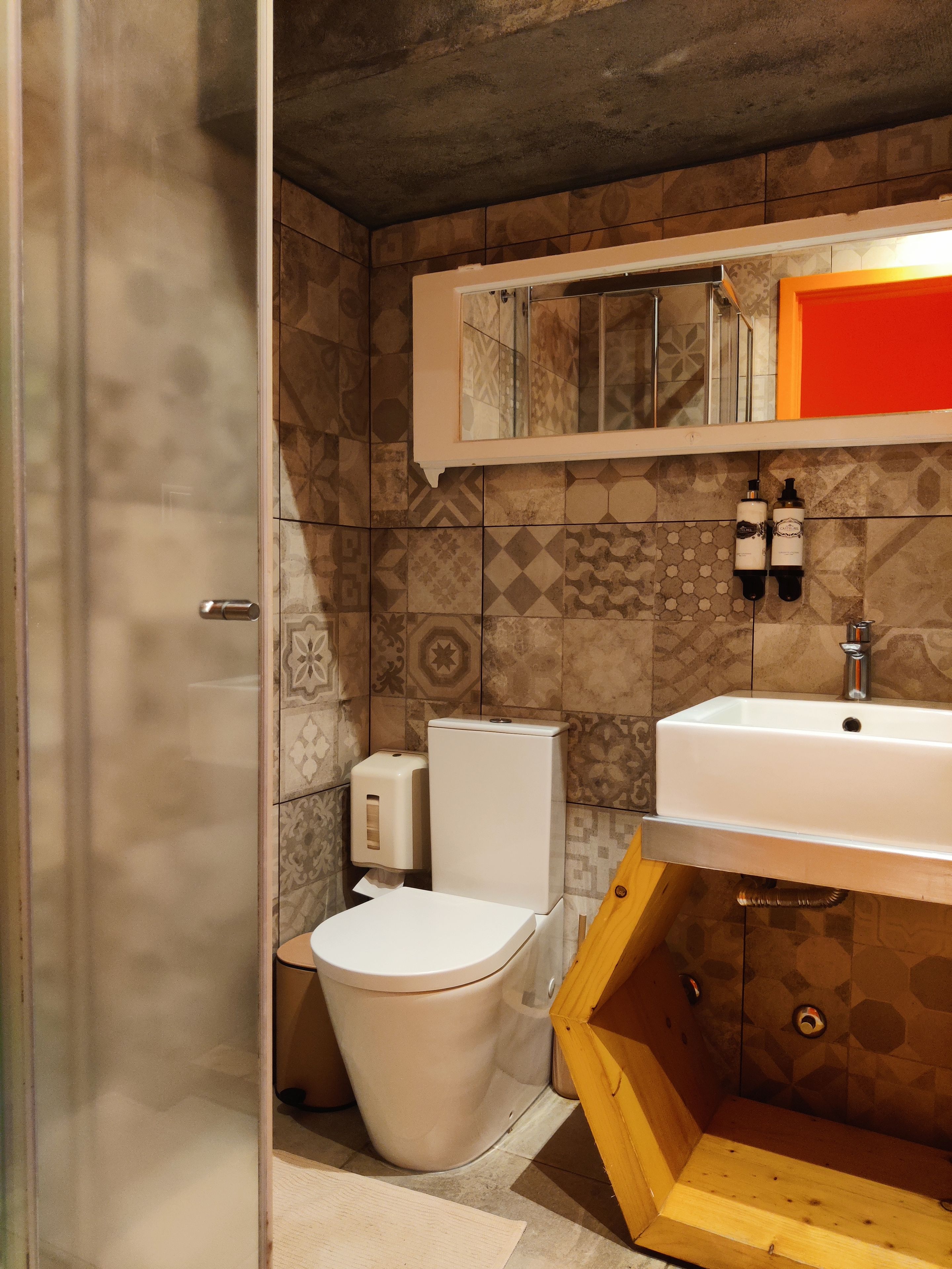 A bathroom with a toilet, a sink, and a shower area.