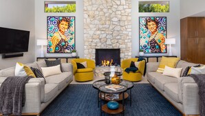 A living room with two sofas, a fireplace, and two paintings.