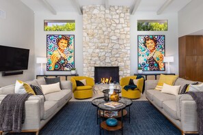 A living room with two sofas, a fireplace, and two paintings.