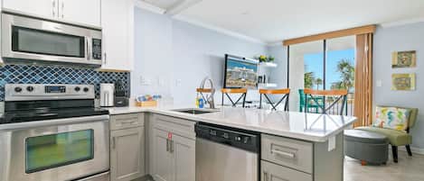 A modern kitchen with stainless steel appliances, a dishwasher, and a large island.