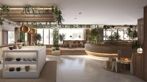 Un intérieur moderne avec un espace salon central, un bar et des étagères où sont disposés des bols et des assiettes.