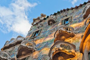 A building with unique architectural design, featuring balconies with ornate metalwork and a mosaic tile facade. - ME Barcelona (Barcelona)