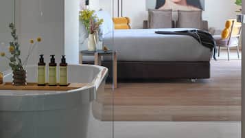 Un dormitorio moderno con cama, mesita de noche, lámpara y un cuadro grande en la pared.