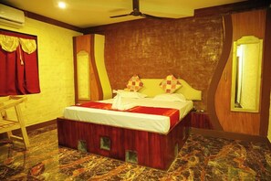 A hotel room with a bed, a desk, and a chair. - Navagiraga Resorts & Hotel (Sirkazhi)