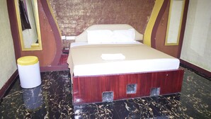 Una habitación con una cama, un cesto de basura y un espejo.