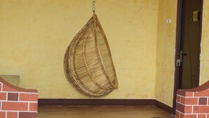 Una silla colgante en una habitación con suelo de madera y una puerta con el símbolo del número.
