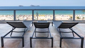A beach view from a balcony with three metal-framed lounge chairs. - Penthouse Overlooking Ipanema Beach Vsc2 (Rio de Janeiro)