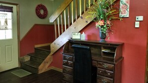 A staircase with wooden railings, a vase with flowers, a 'Wi-Fi' sign, and a red wall.