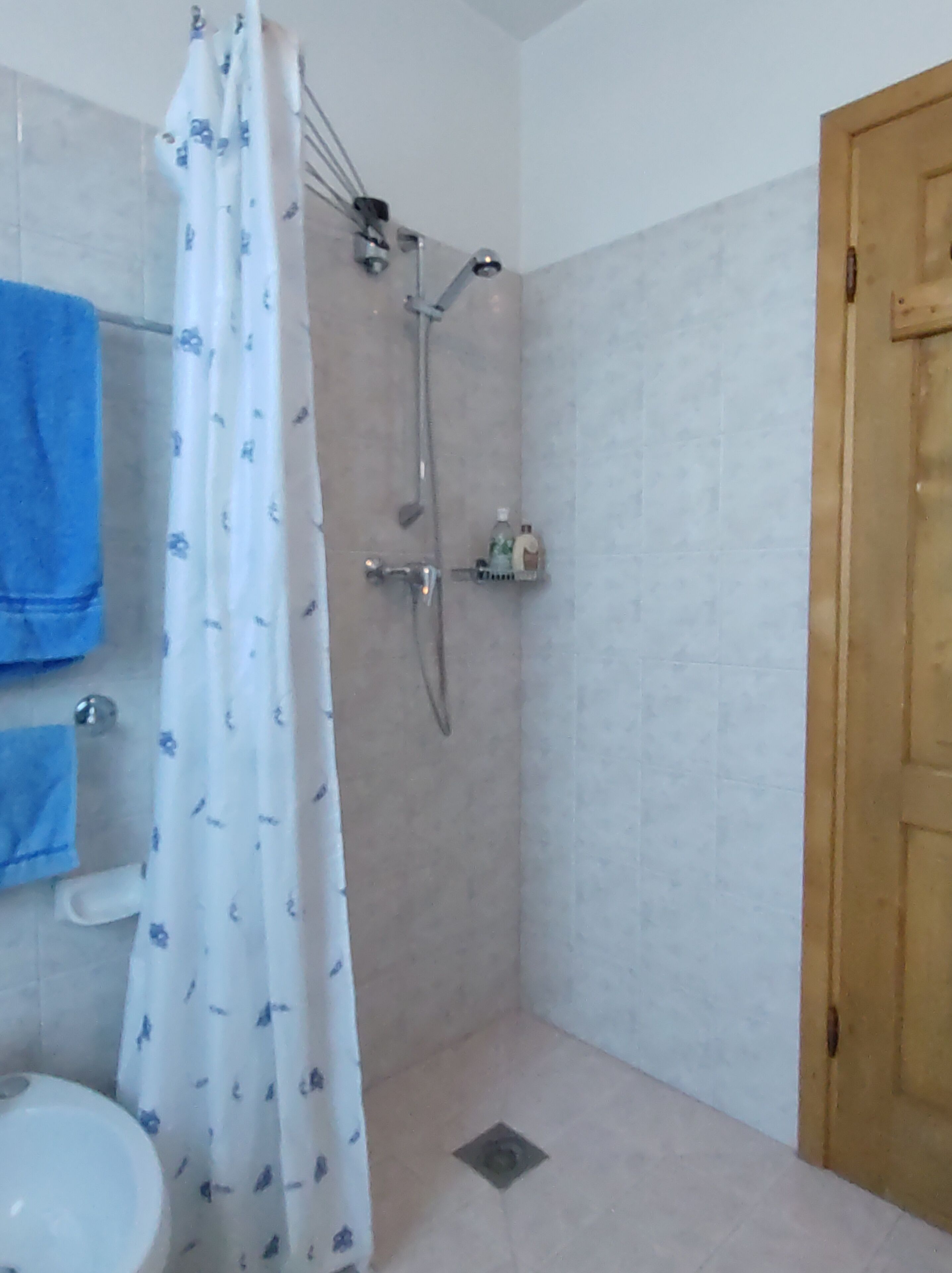 Een badkamer met een douche, toilet en wastafel.