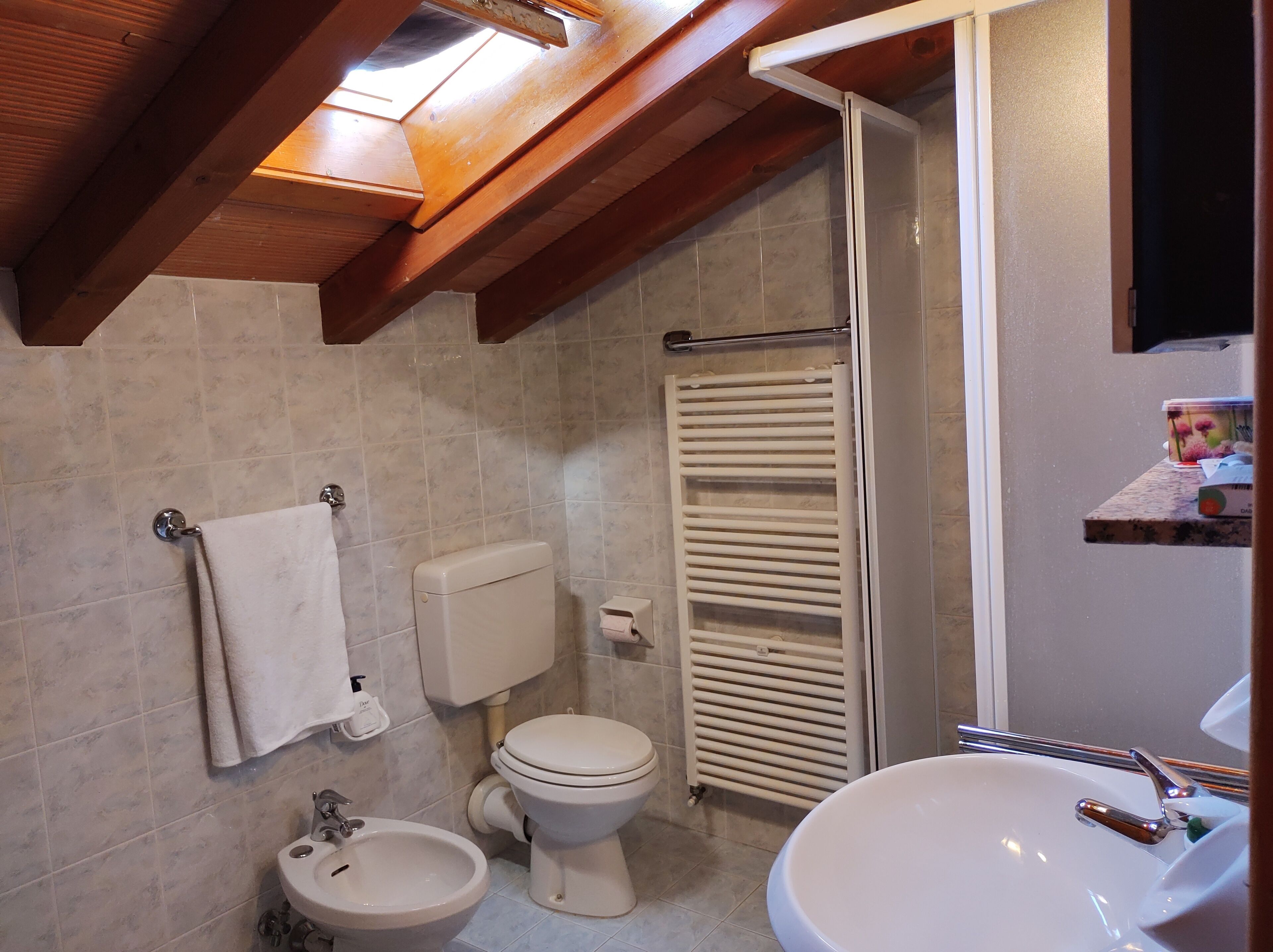Un bagno con servizi igienici, bidet, lavandino e porta asciugamani.