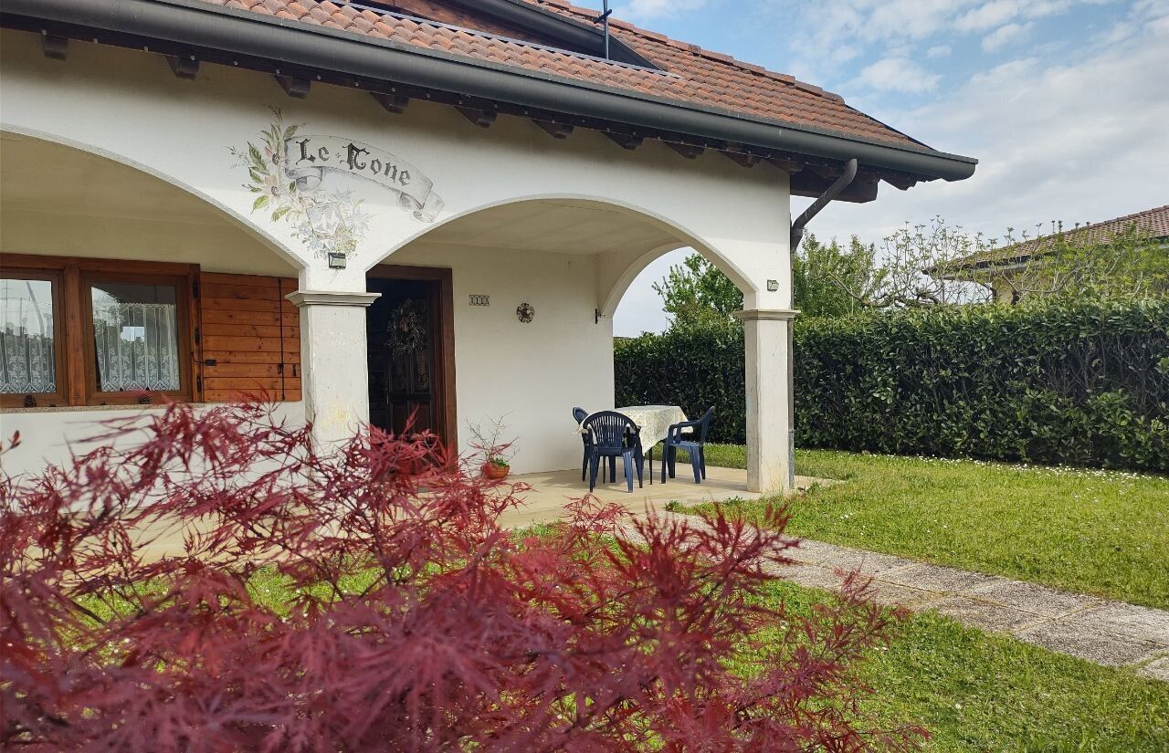 A building with a sign reading "Le Conte" and a covered patio area with two chairs and a table.