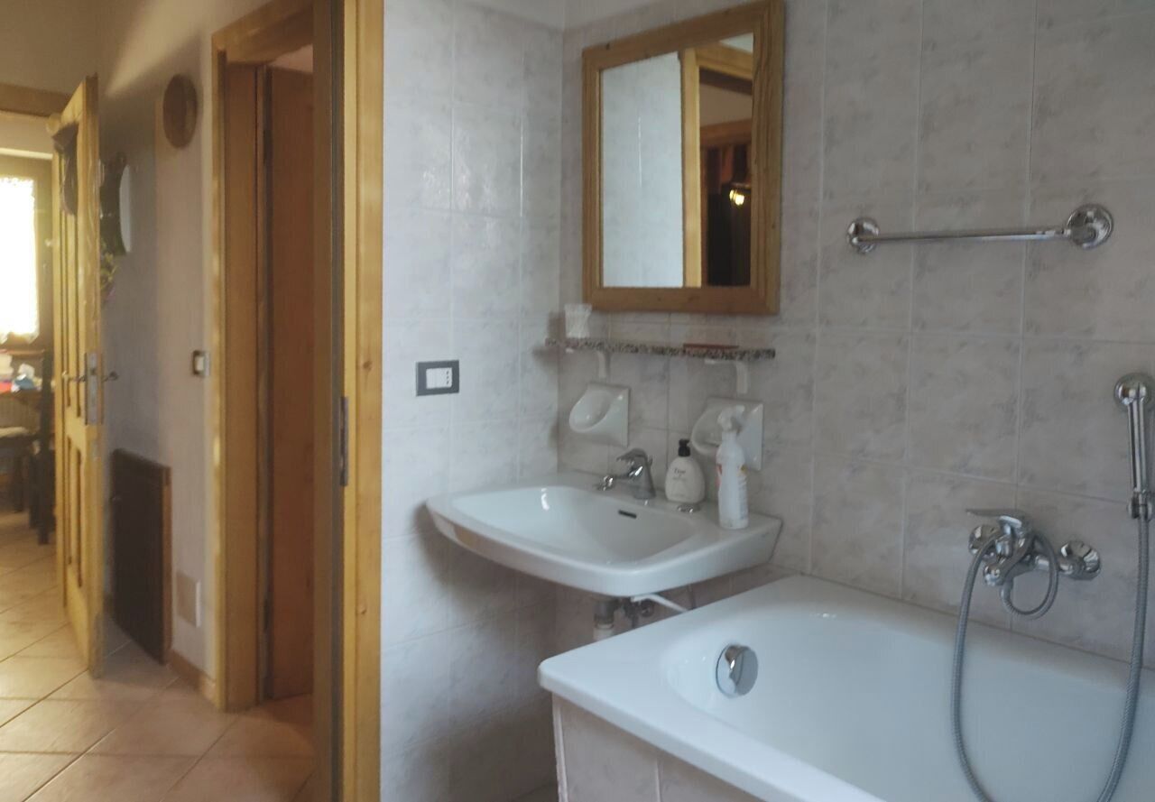 Un baño con dos lavamanos, una bañera y una ducha.
