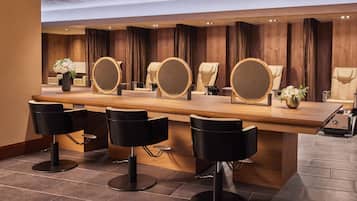 Un área de bar moderna con una barra de madera, varios taburetes y espejos redondos.