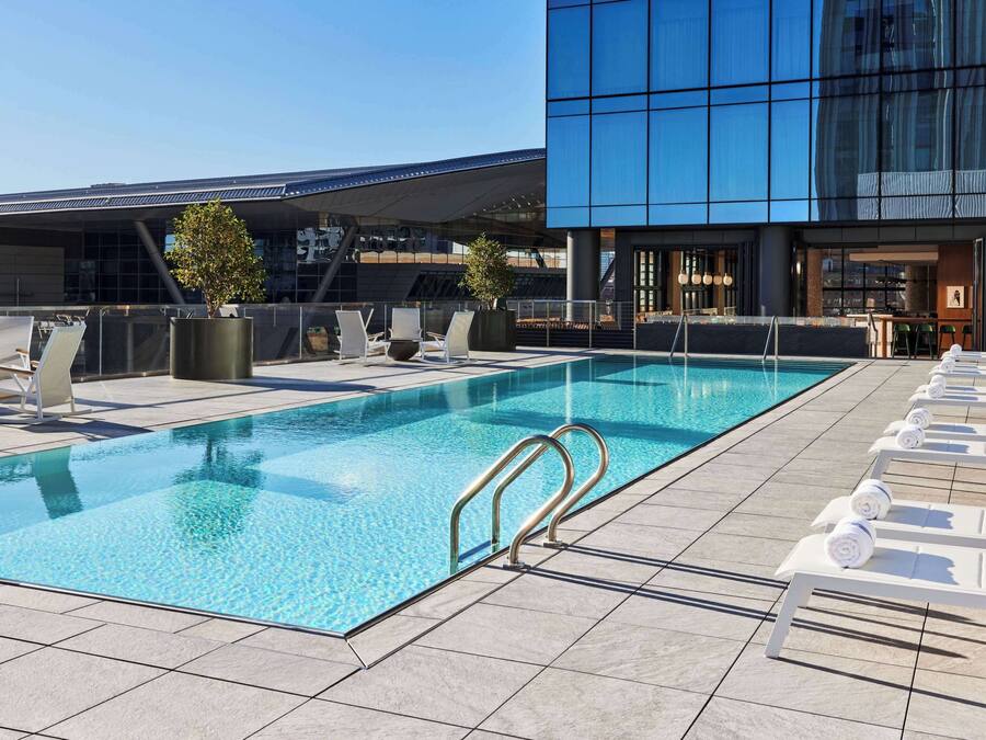 Una piscina al aire libre, sillones reclinables de piscina