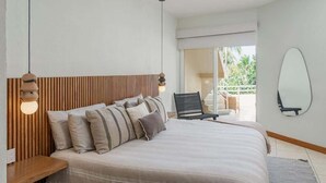 Un dormitorio con una cama grande, cabecera de madera, lámpara colgante y vistas al exterior.
