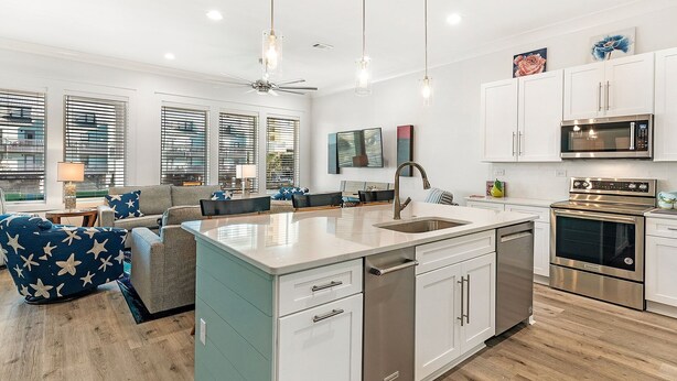 A modern kitchen with white cabinetry, stainless steel appliances, and a central island with a sink. - 😎 Night Heron, West. ⭐️⭐️⭐️⭐️⭐️ 6BR. Heated Pool. Beachview. Gorgeous! (Gulf Shores)