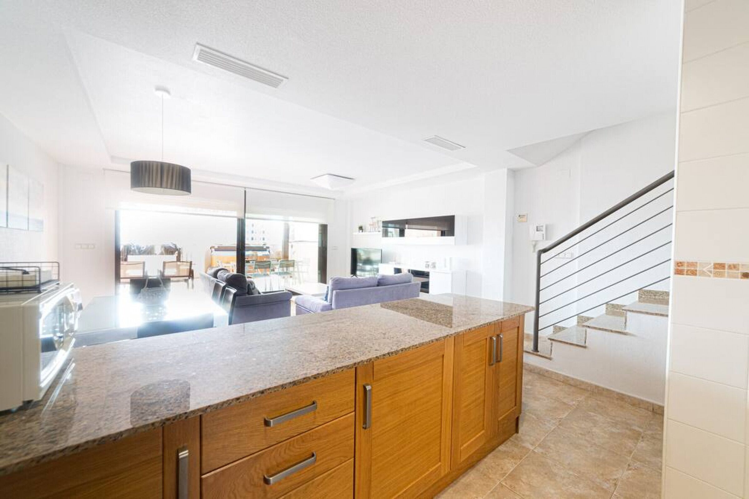 A modern kitchen with granite countertops, wooden cabinets, and a central island.