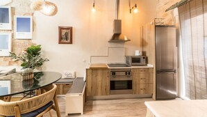 Una cocina moderna con armarios de madera, electrodomésticos de acero inoxidable y una mesa de comedor de vidrio.