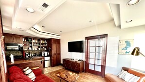 A modern living room with a red sofa, a wooden coffee table, and a brown leather couch.