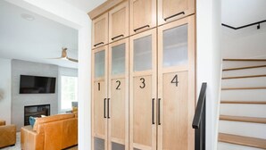 Een moderne woonkamer met een houten kast genummerd 1 tot 4, een bank, een flatscreen televisie en een open haard.
