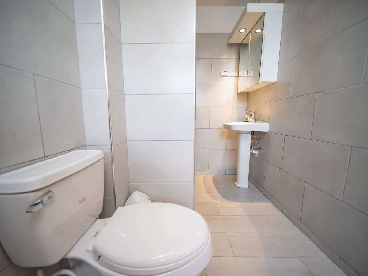 Een bad/douchecombinatie, handdoeken, toiletpapier