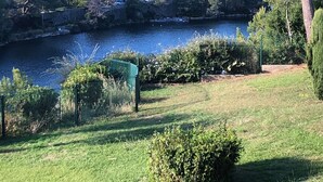 A lakeside view with a fenced area, trees, and a distant building. - St Raphaël/App 4 pers/superb sea view/pool/wifi/climate (Saint-Raphaël)