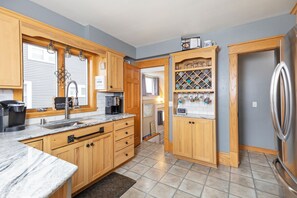 Enjoy cooking in this well-equipped kitchen with a refrigerator, wine rack, and ample storage.