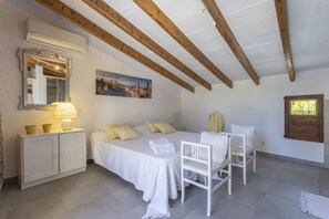 A bedroom with a bed, bedside table, and a chair.