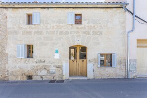 A stone building with a wooden door and shuttered windows.