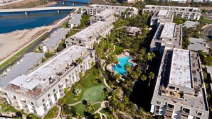 Vista aérea de un resort con varias edificaciones, una piscina y un río.