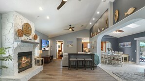 A spacious living area with a fireplace, a dining area, and a kitchen. - HEATED Saltwater POOL, Harry Potter, BBQ, Lake, Fishing, Gazebo, Games & Firepit (St. Augustine)