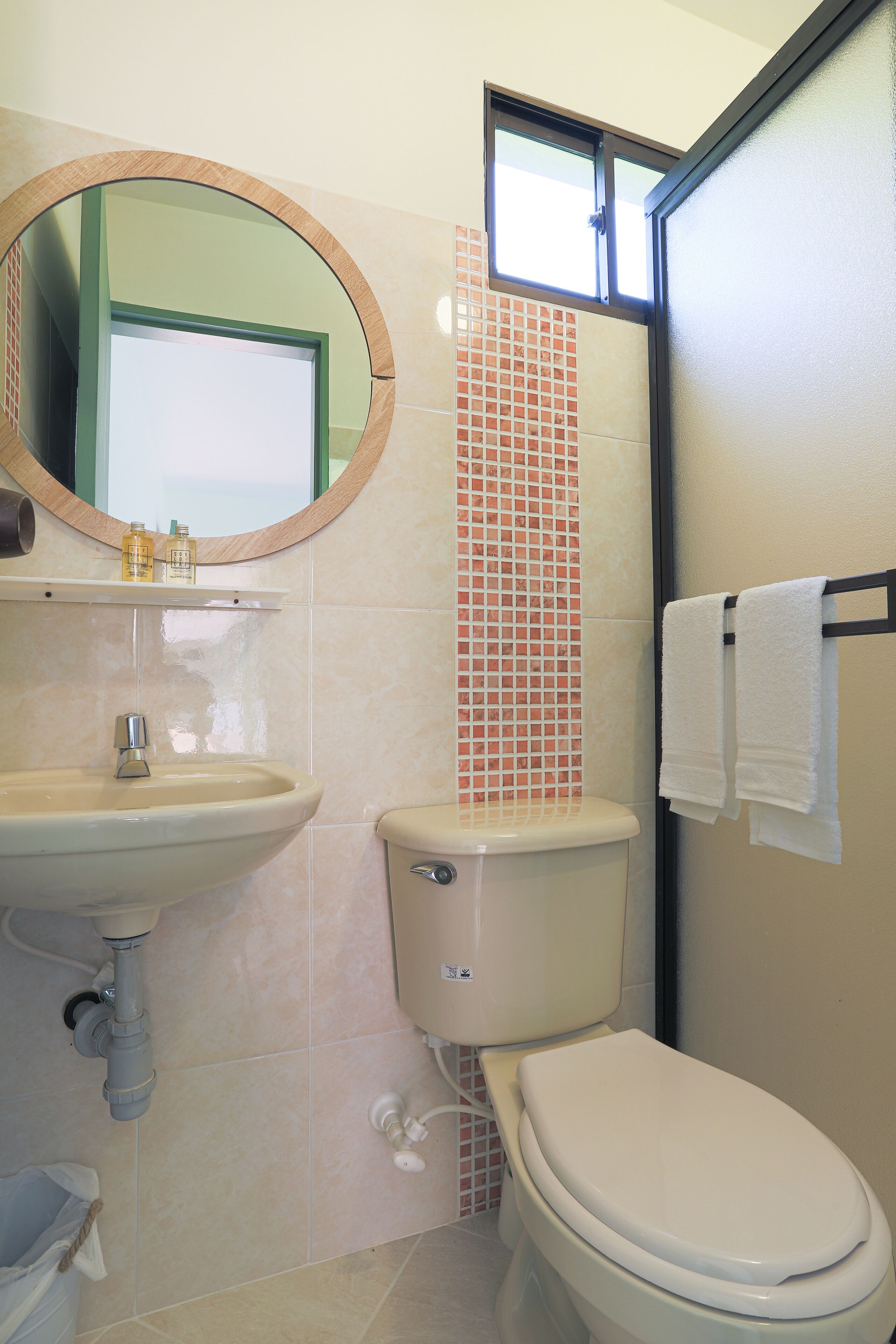 A bathroom with a sink, toilet, and a mirror.