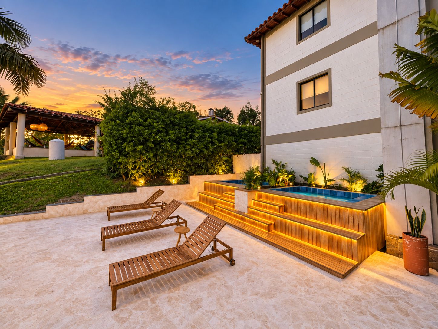 A poolside area with lounge chairs, a wooden deck, and a modern building with a white facade.